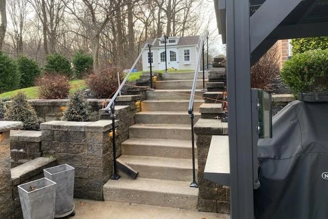 Photo of black metal railing for stone outdoor residential staircase in the backyard