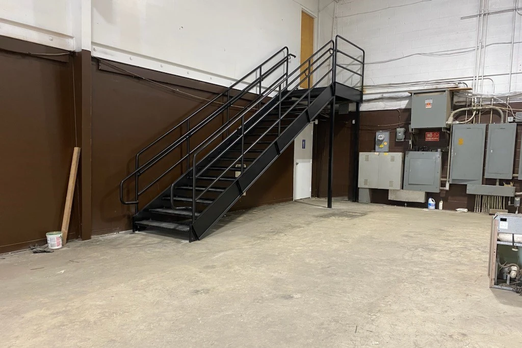 Photo of black metal staircase in industrial setting, far view